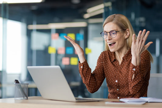 A happy woman participating in a Group Coaching for neurodiverse leaders video call with her hands open and facing her in a gesture of revelation, an "a-ha" moment